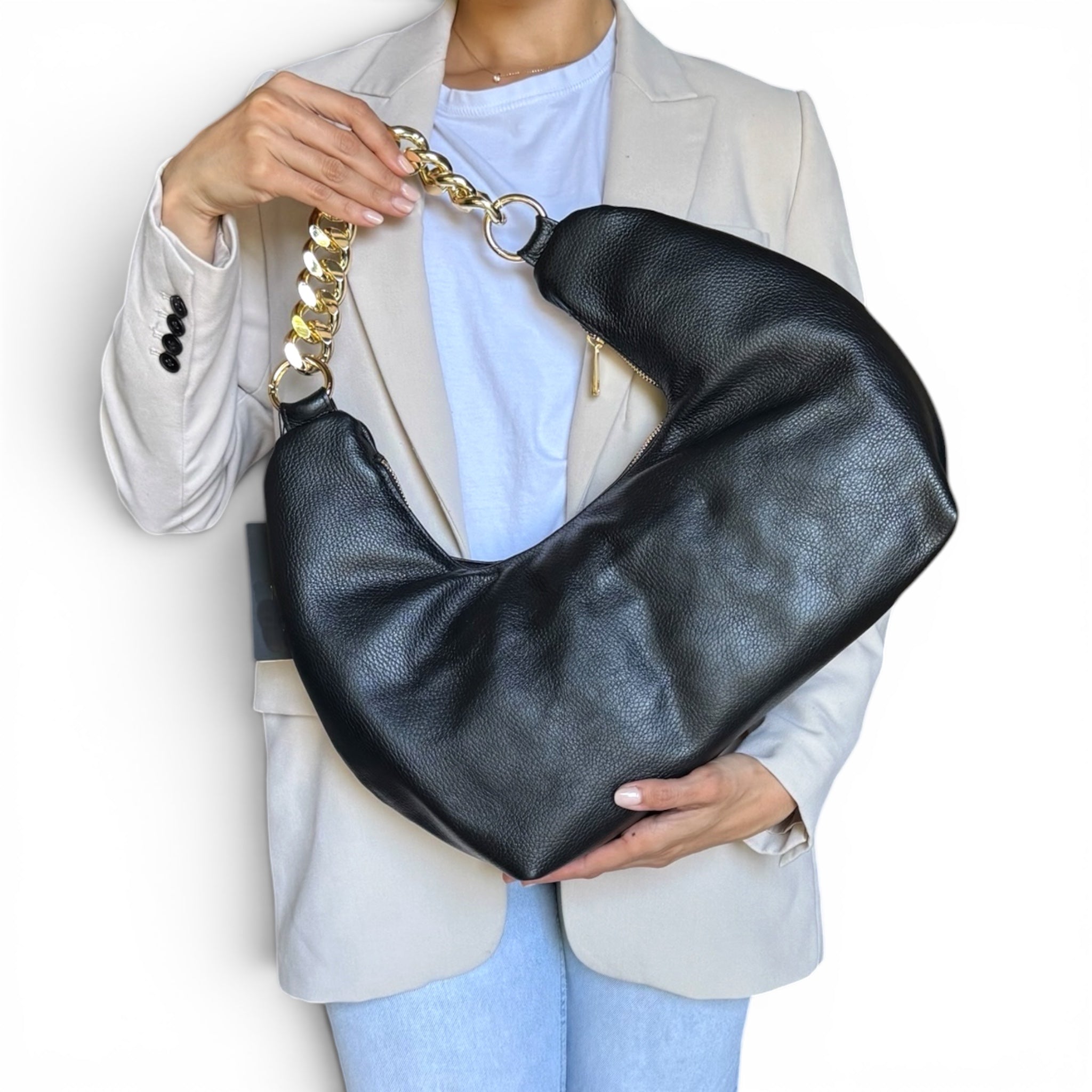 model holding fiorenza black leather handbag with a gold chain strap on a white background