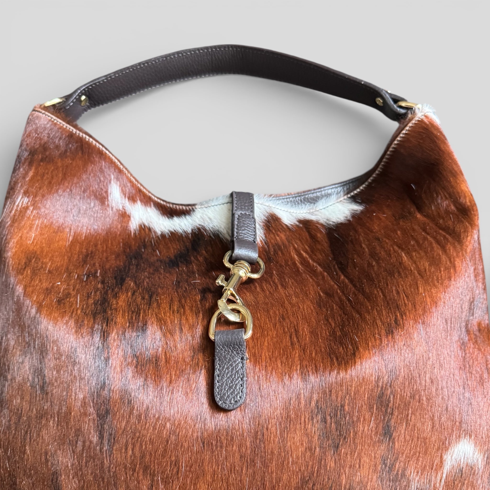 Close-up of gold-tone hardware on genuine Italian hair calf leather handbag