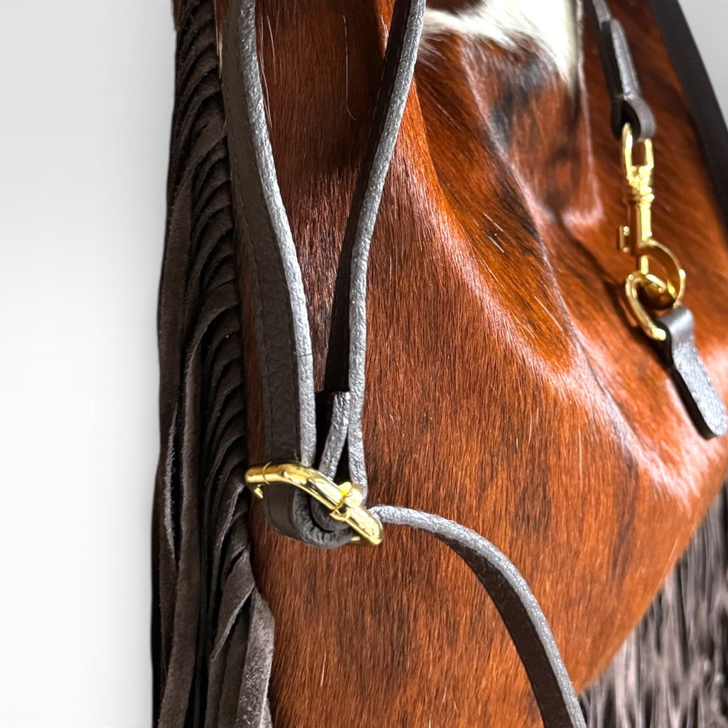 Adjustable leather shoulder strap on Italian handcrafted fringe handbag.