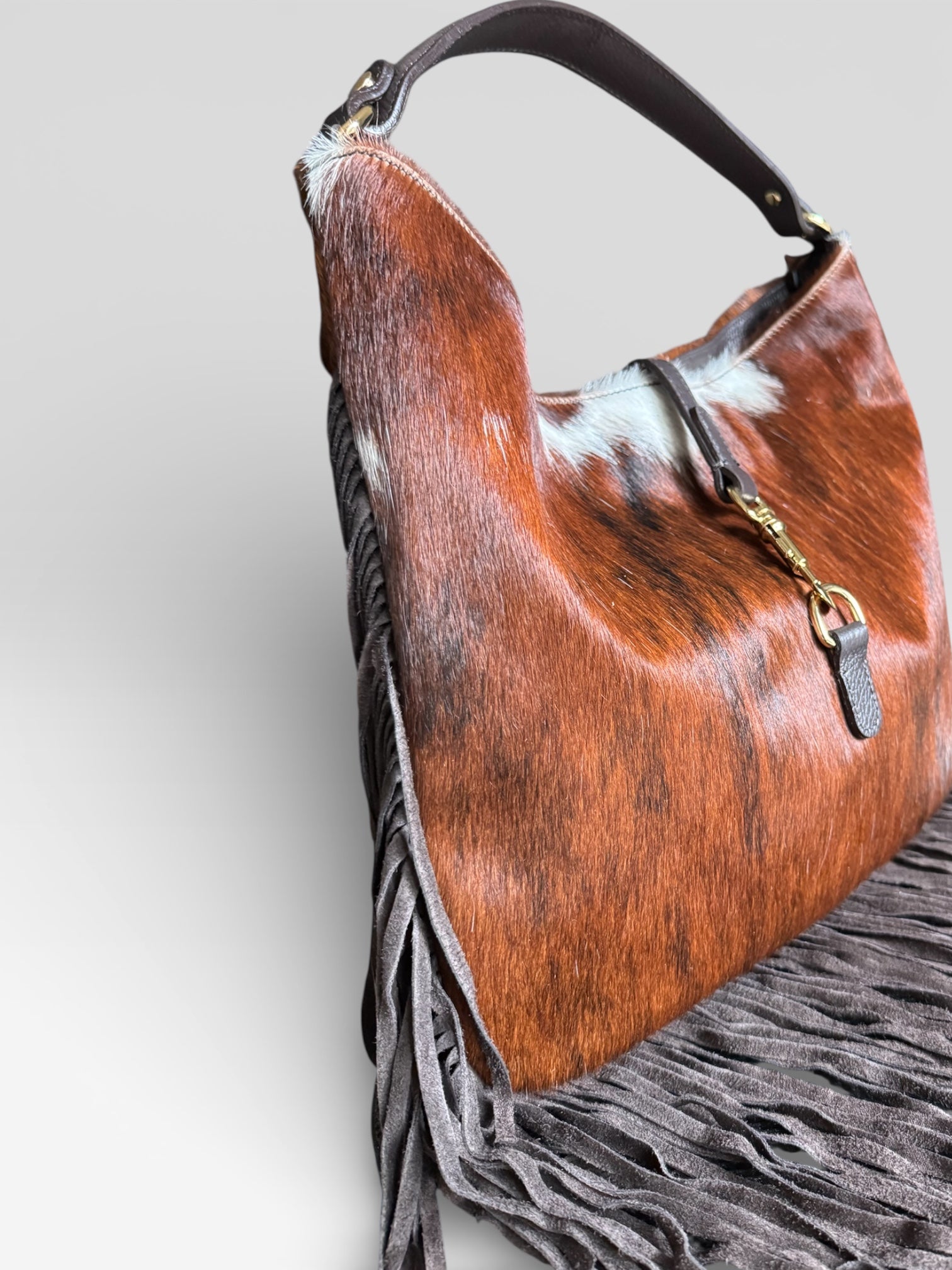 Side view of handmade Italian hair calf leather fringe shoulder bag.