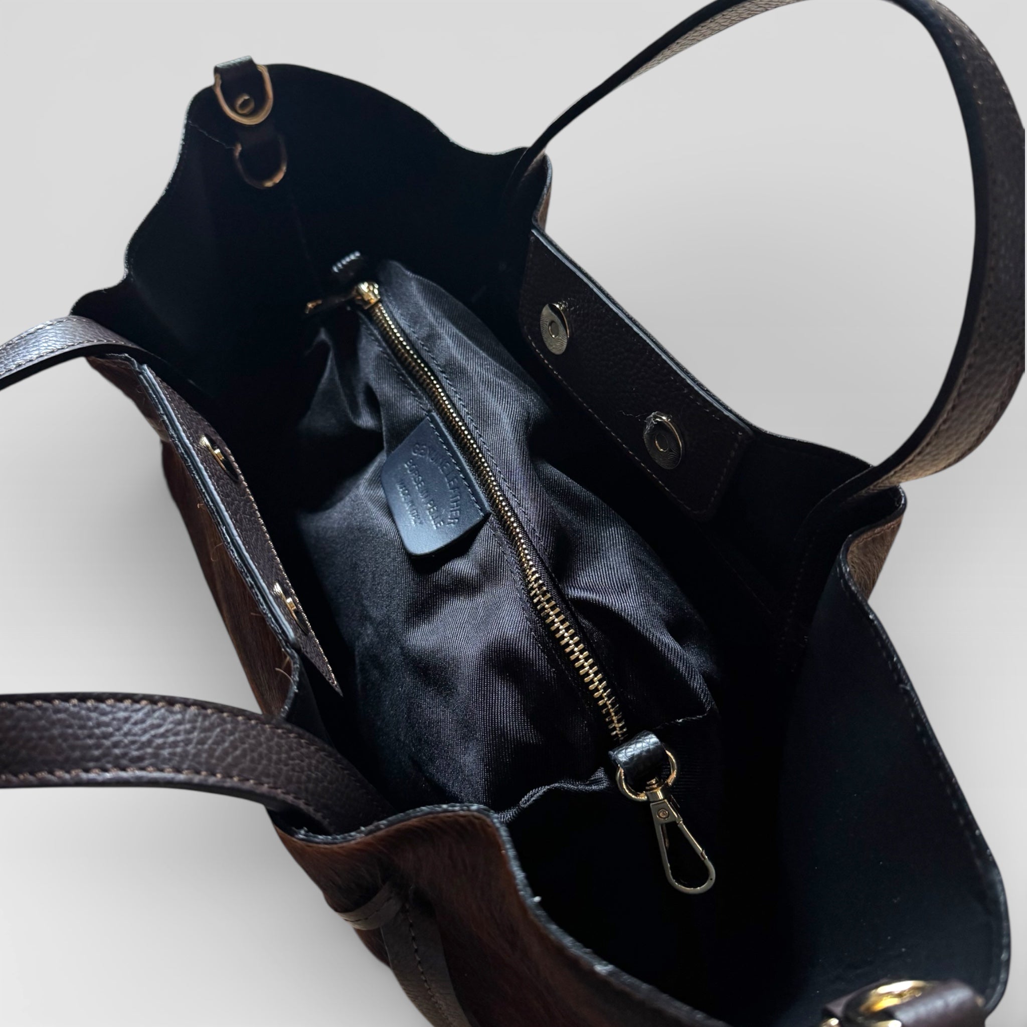 Close-up of the removable interior zip pouch inside the Italian hair calf leather tote bag.