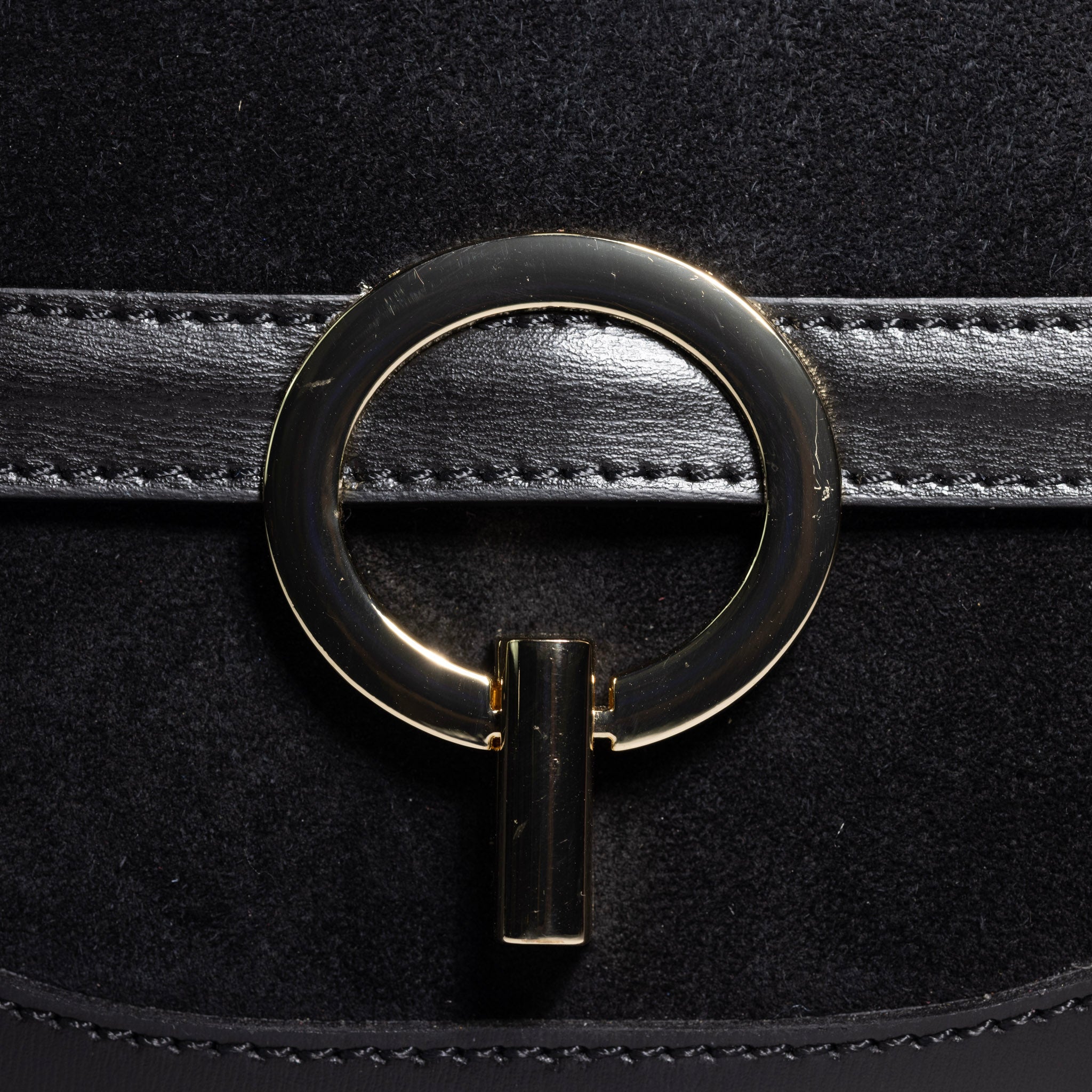gold hardware detail on suede leather handbag